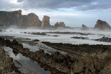 rocky and wild coast with stormy waves hitting the shore