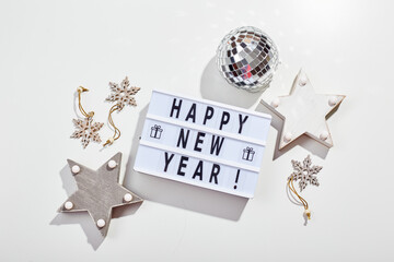 Light box inscription Happy New Year, mirrored disco ball and wooden star decorations