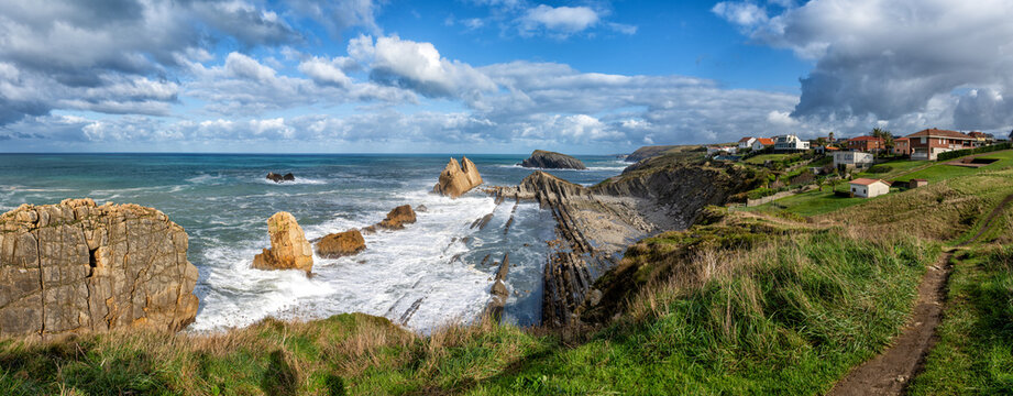 panorama of a rocky and wild coast with stormy waves hitting the shore