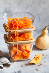 Glass boxes with fresh raw orange vegetables. Finaly shredded pumpkin and big pieces. Healthy Meal Prep, recipe preparation photos. Healthy vegan dishes in glass containers. Weight loss food concept