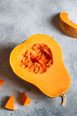 Fresh butternut squash on the grey background. Butternut Pumpkin. Halves of raw orange pumpkin. Contrast photo. Healthy Meal Prep, recipe preparation photo. Seasonal pumpkin cooking