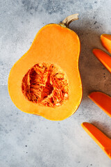 Fresh butternut squash on the grey background. Butternut Pumpkin. Halves of raw orange pumpkin. Contrast photo. Healthy Meal Prep, recipe preparation photo. Seasonal pumpkin cooking