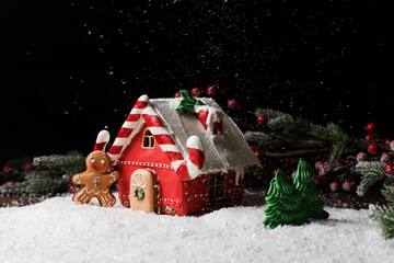 Christmas gingerbread house with Christmas decorations on black background. Traditional Christmas baking.