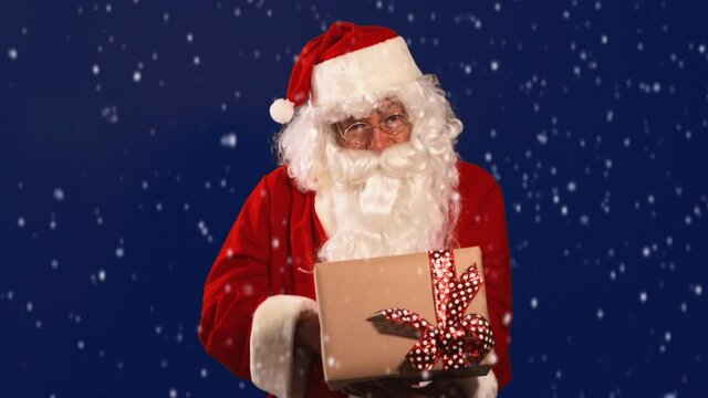 Santa riendo y dando regalo con nieve en navidad
