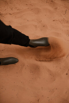 foot kicking up orange sand