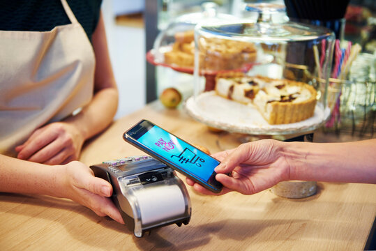 Customer paying cashless with smartphone in a cafe