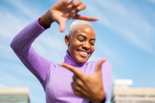 Portrait of mature woman shaping frame with her fingers