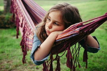 Portrait of sad girl lying in hammock