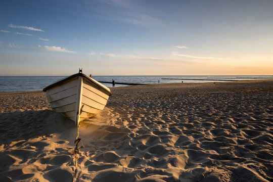 Boat left on sandy beach at dawn