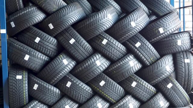 Stack of car tires on warehouse in tire store, close up, 4K