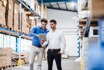 Two businessmen having a meeting in company warehouse