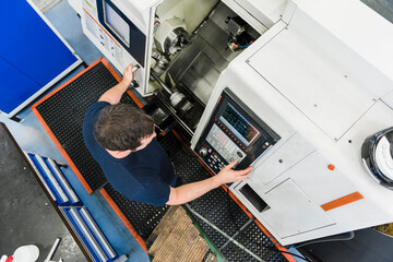 Top view of man operating machine in industrial factory