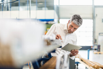 Businessman using tablet in production hall