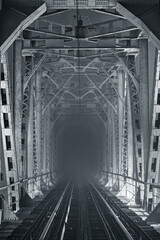 Night, illuminated railway bridge in black and white tones