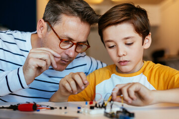 Father and son assembling an electronic construction kit