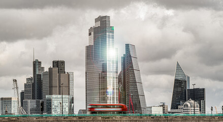 Fototapeta na wymiar City of London With Sun Flare with Dark Cloud and Red Double Decker Buse Facing East