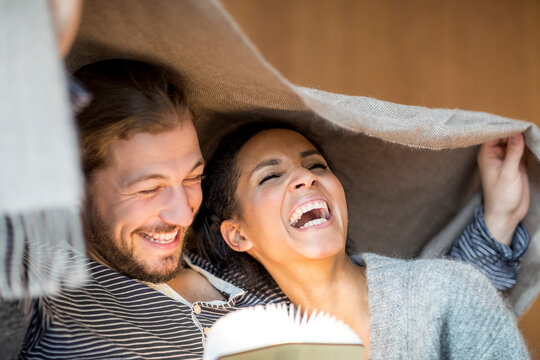 Portrait of laughing young couple at home