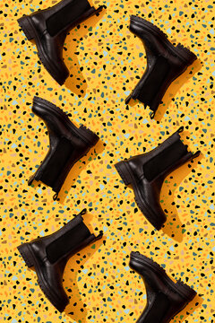 Black leather boots on yellow terrazzo pattern