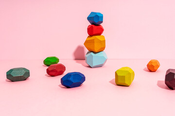 Stack of multi colored wooden block against pink background