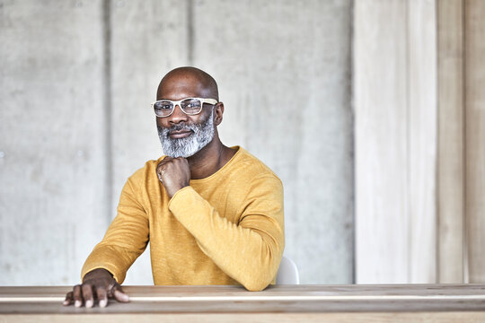 Portrait of confident mature businessman sitting at desk in office