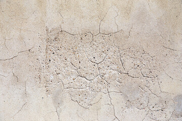 Old cracked plaster wall, weathered texture background for design. Poor quality work
