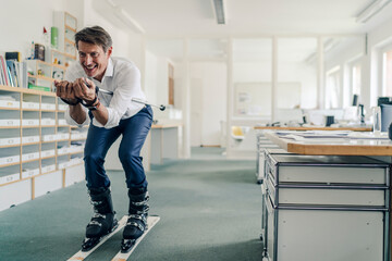 Businessman skiing in office