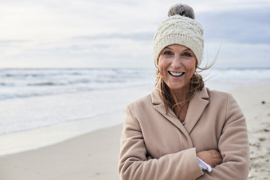 Spain, Menorca, portrait of happy senior woman on the beach in winter