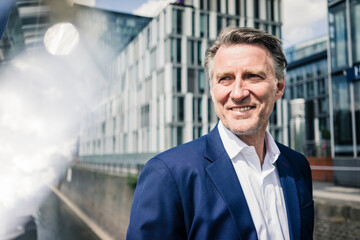 Portrait of smiling mature businessman outdoors