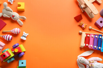 Flat lay composition with different toys on orange background. Space for text