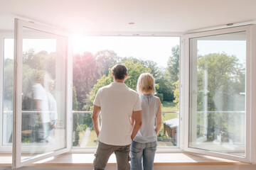 Mature couple looking out of window into the sun
