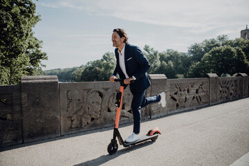 Businessman with e-scooter on a bridge