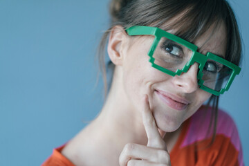 Young woman wearing pixel glasses, smiling