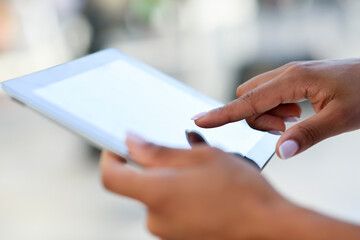 Close-up of woman's hands using tablet outdoors