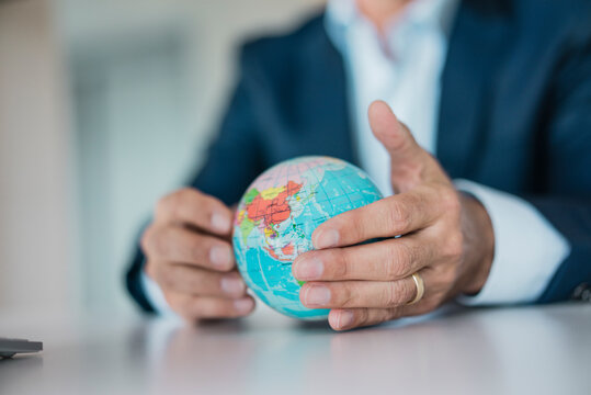 Close-up of hands of businessman holding globe