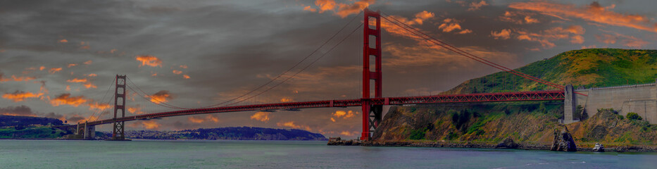 Sunsets breaks through a rainy day sky while clouds break up by the Golden Gate Bridge