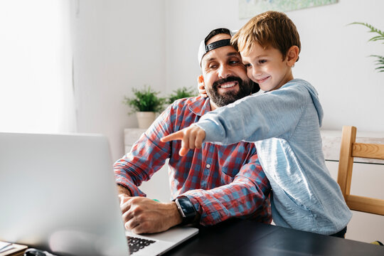 Father and son using laptop together