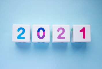 Obraz premium Cubes with colorful numbers 2021 on blue background. New year, calendar