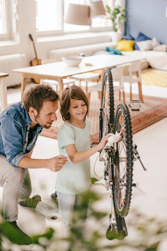 Father and son repairing bicycle together at home