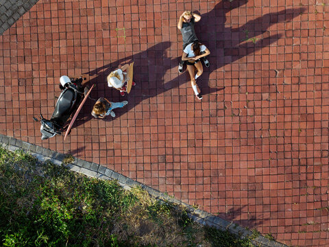 Indonesia, Bali, Aerial view of group of friends hanging around cobblestoned area