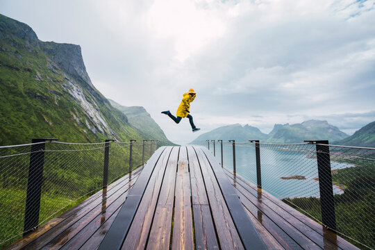 Norway, Senja island, man jumping on an observation deck at the coast