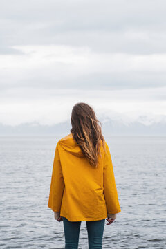 Iceland, woman standing at the sea