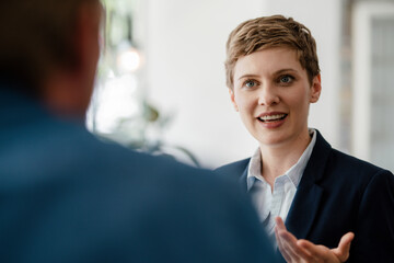 Portrait of businesswoman talking to a colleague