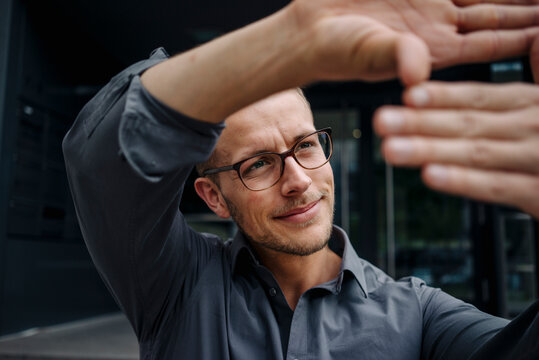 Portrait of smiling businessman making finger frame