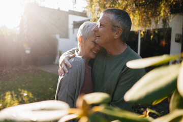 Happy affectionate senior couple hugging in garden
