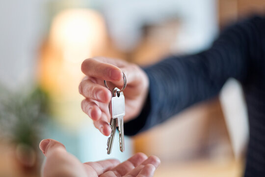Close-up of hand over of house key in new home