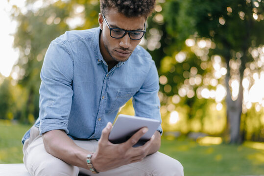 Young man looking at cell phone in park