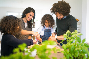 Happy family baking pizza at home