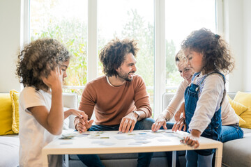 Family sitting on couch , playing memory game