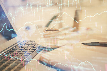 Double exposure of financial chart drawing and desktop with coffee and items on table background. Concept of forex market trading