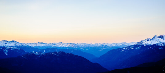 Fototapeta na wymiar Dark snow-capped mountains at dusk.